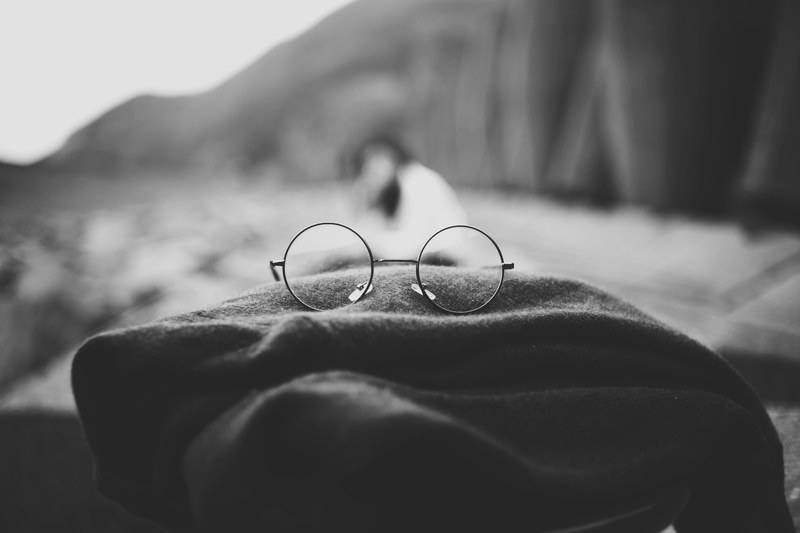 black and white macro of round rimmed spectacles lying on fabric in da nang, macro spectacles in da nang 4k