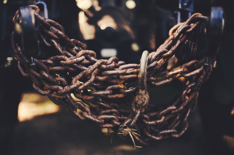 rusty brown chains wrap around each other on a locked up gate, farm life 4k