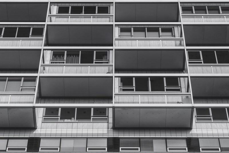 black and white shot of urban building with balconies and windows, monochrome urban balconies 4k