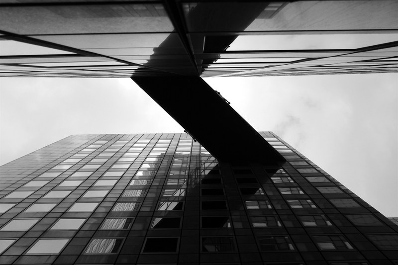 a low angle shot of a skyway connecting two office buildings, building skyway bridge 4k