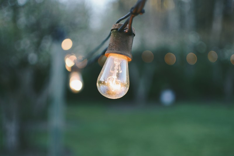 close up of a light bulb on a long horizontal wire outdoors, light bulb on a wire outdoors 4k