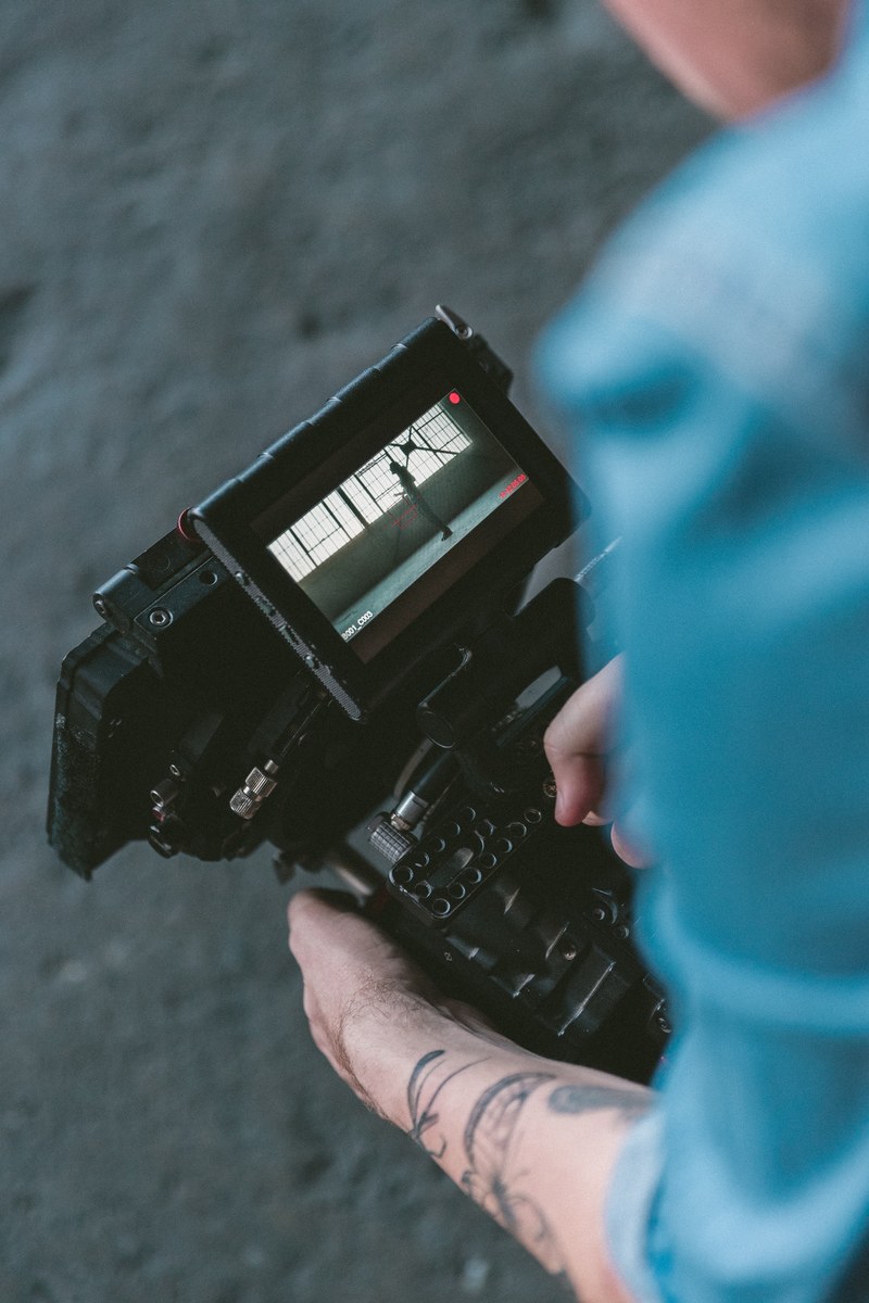 a man with a video camera watching the recorded footage, music video 4k