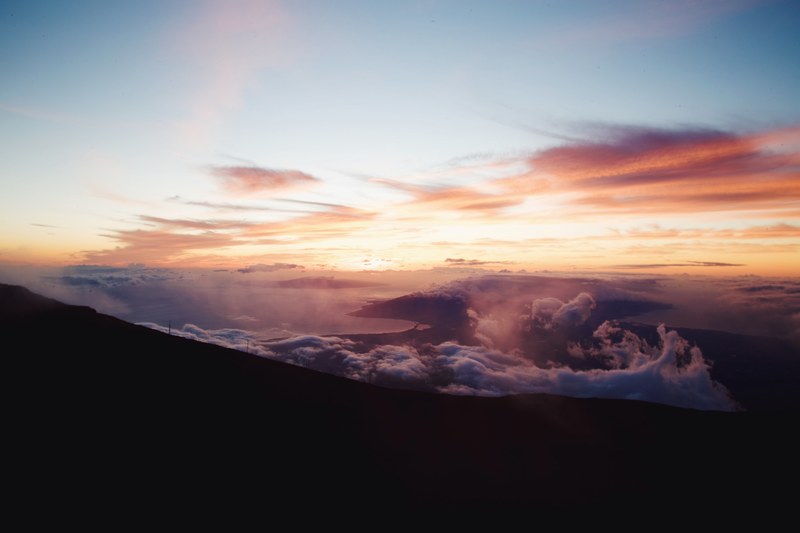 swirling clouds and sunset over a scenic lake from atop a mountain, clouds over the mountains and lake 4k