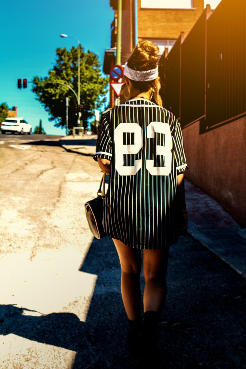 a woman in a striped black shirt walking along a road in madrid, 93 4k