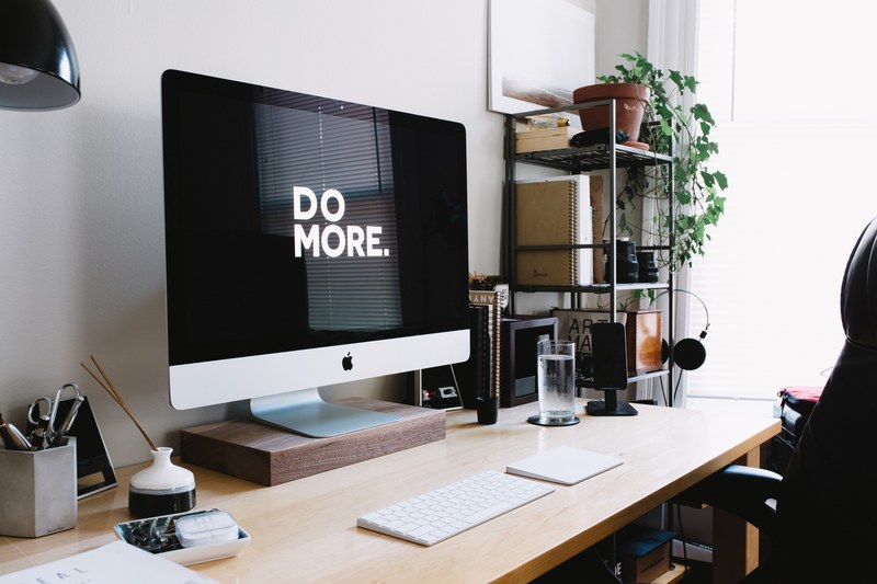 an imac with do more displayed on its screen on a wooden desk, desktop workspace 4k