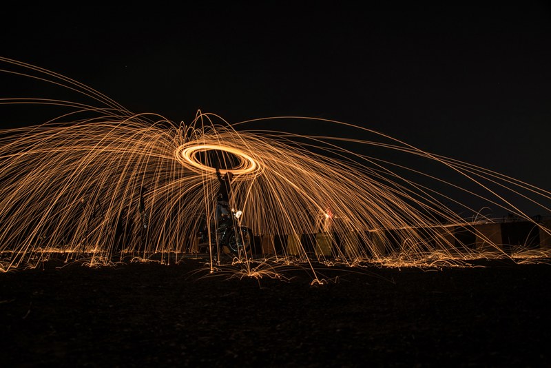 a long exposure shot of a light painting at night in the city indian city nagpur, steelwool man 4k