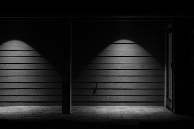 black and white shot of wooden wall with light and shadow and door, wall shadow and door 4k