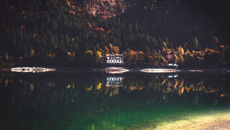 a hotel on a wooded shore of a jade green lake, lakeside hotel 4k