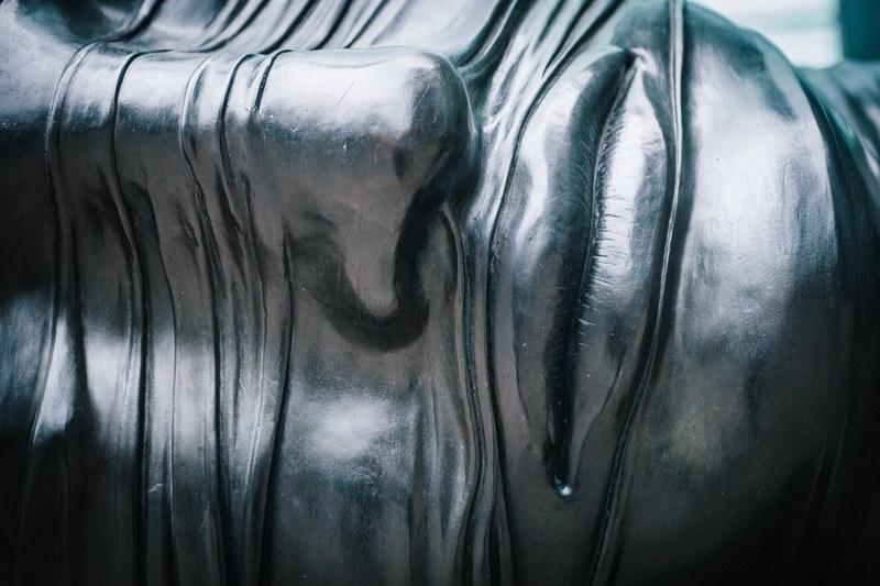 close up of modern metal sculpture of human face at canary wharf, lips of steel 4k
