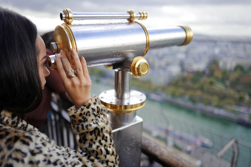 a fashionable woman looking over a river through a viewfinder telescope, woman looking through viewfinder 4k