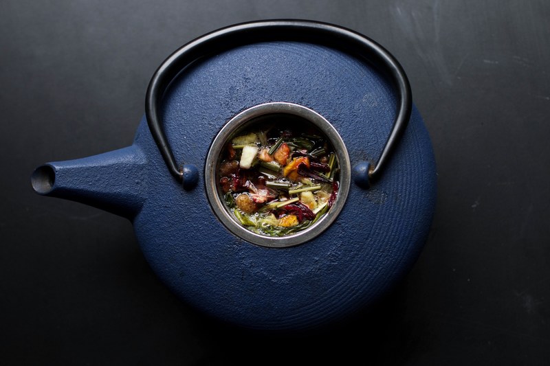 overhead view of a blue kettle teapot filled with herbs at laguna beach, blue kettle filled with herbs 4k