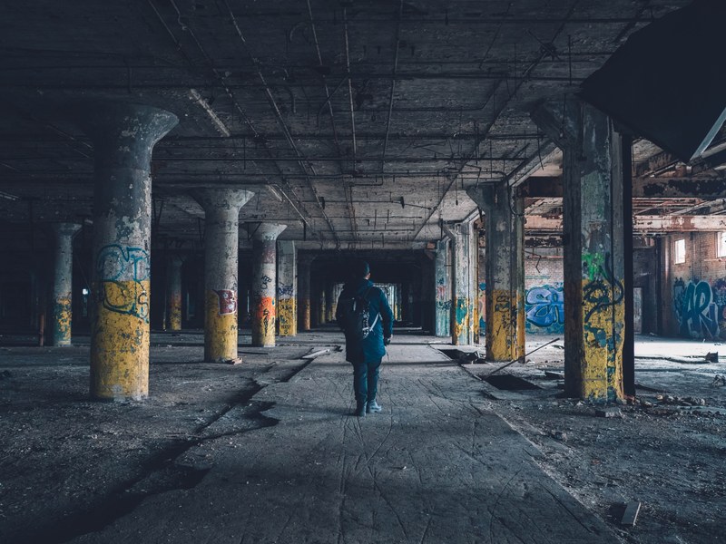 a man standing in an abandoned parking garage thats filled with graffiti in detroit, detroit graffiti 4k