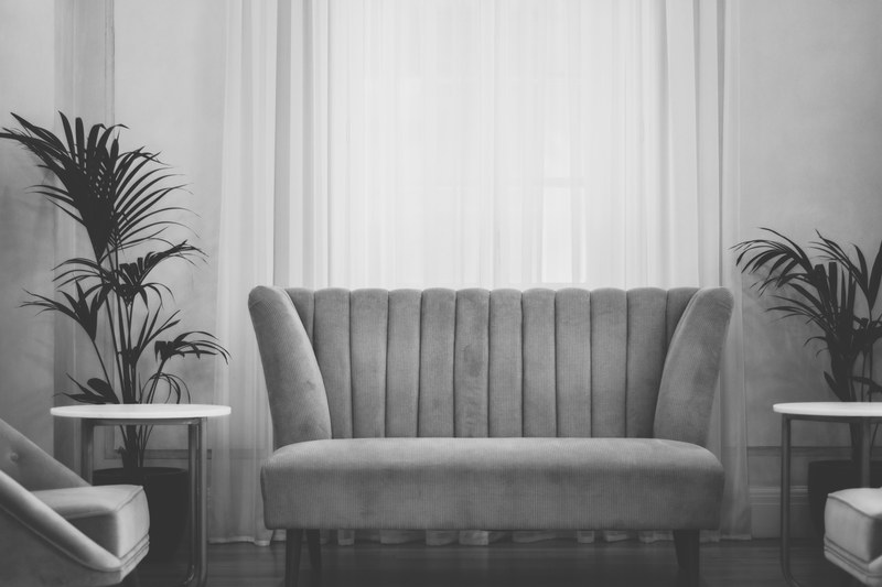 modern living room with a couch and two tables and plants and curtains in the background seen through a gray filter, living room grey couch 4k