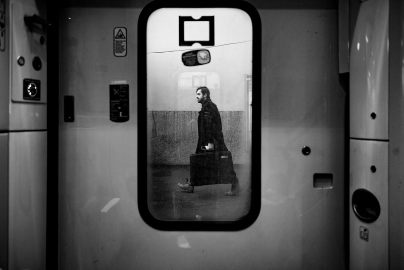 black and white shot through train door window of male commuter walking on platform le havre, at the station 4k