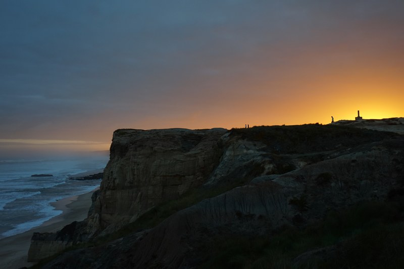 landscape shot featuring beach and ocean at the foot of humongous cliff in peniche, huge peniche cliff 4k