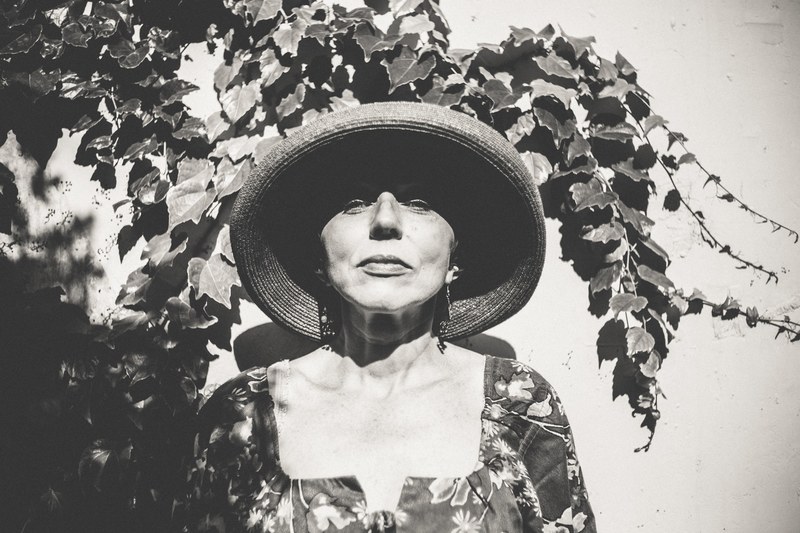 black and white shot of woman in straw hat in front of wall with ivy vine, woman in hat and ivy on wall 4k