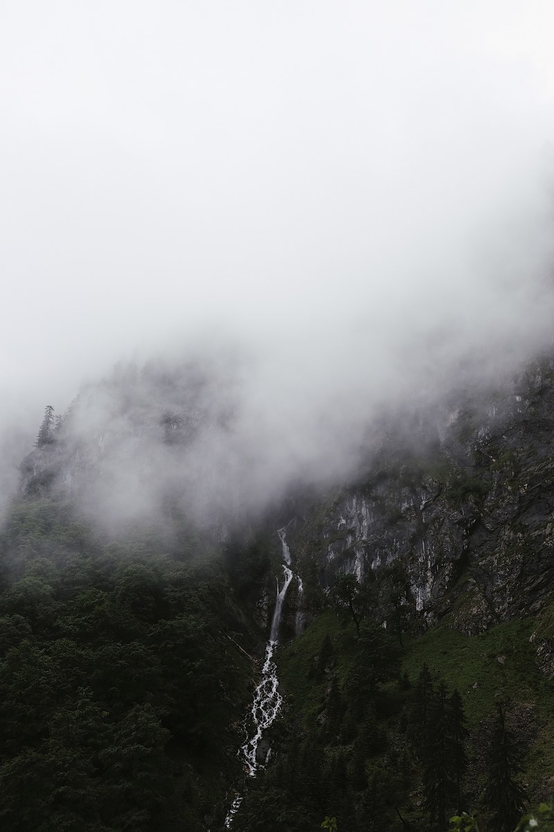 waterfall cascades down a rocky mountainside through the mist in zugspitze, waterfall in the mountains 4k