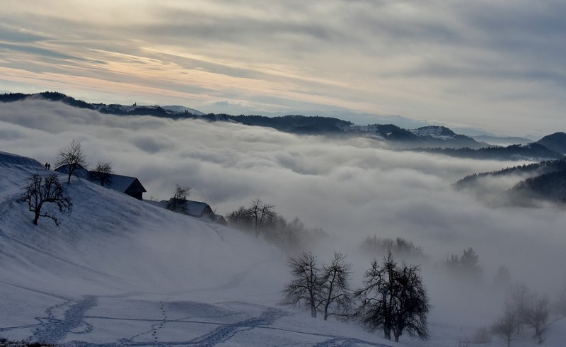 rolling clouds cover winter cabins in a rural valley, rolling fog 4k