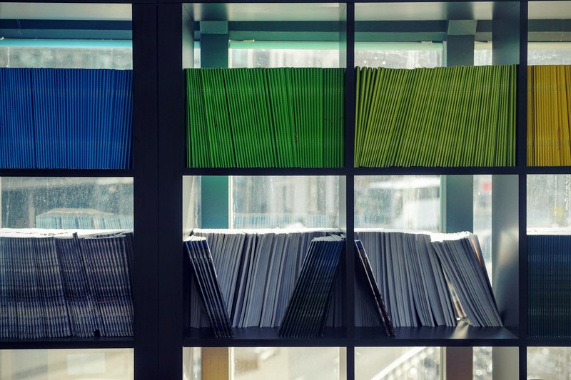 books with uniform colorful covers on bookshelves in a library, colorful bookcase 4k