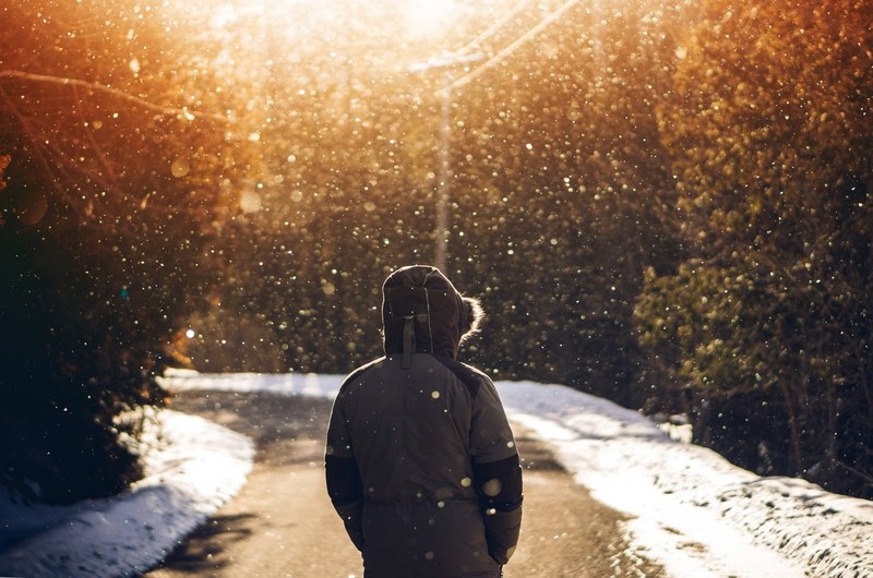 a person wearing a coat with a fur hood and walking along forks of the credit roadin in caledon ontario, ponder 4k