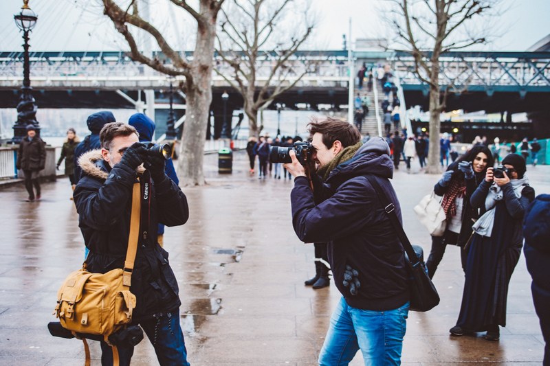 three photographers taking pictures of each other on a street in south bank, cameras at dawn 4k