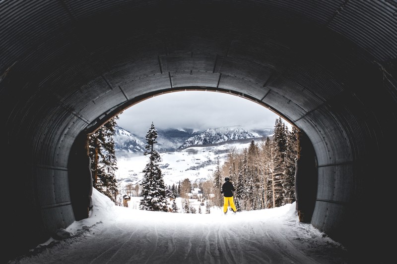 a person passing along a tunnel covering snow in telluride colorado, colorado snow tunnel 4k