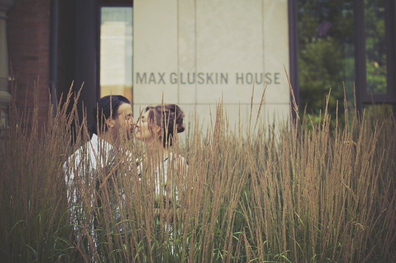 a couple prepares to kiss behind tall grass in front of the max gluskin house, max gluskin house couple 4k