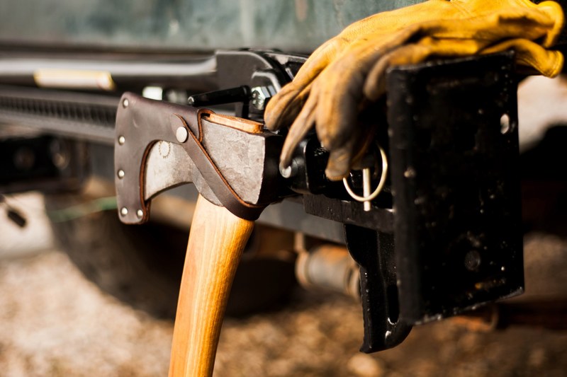an axe in a leather sheath in a workshop, tools of the trade 4k