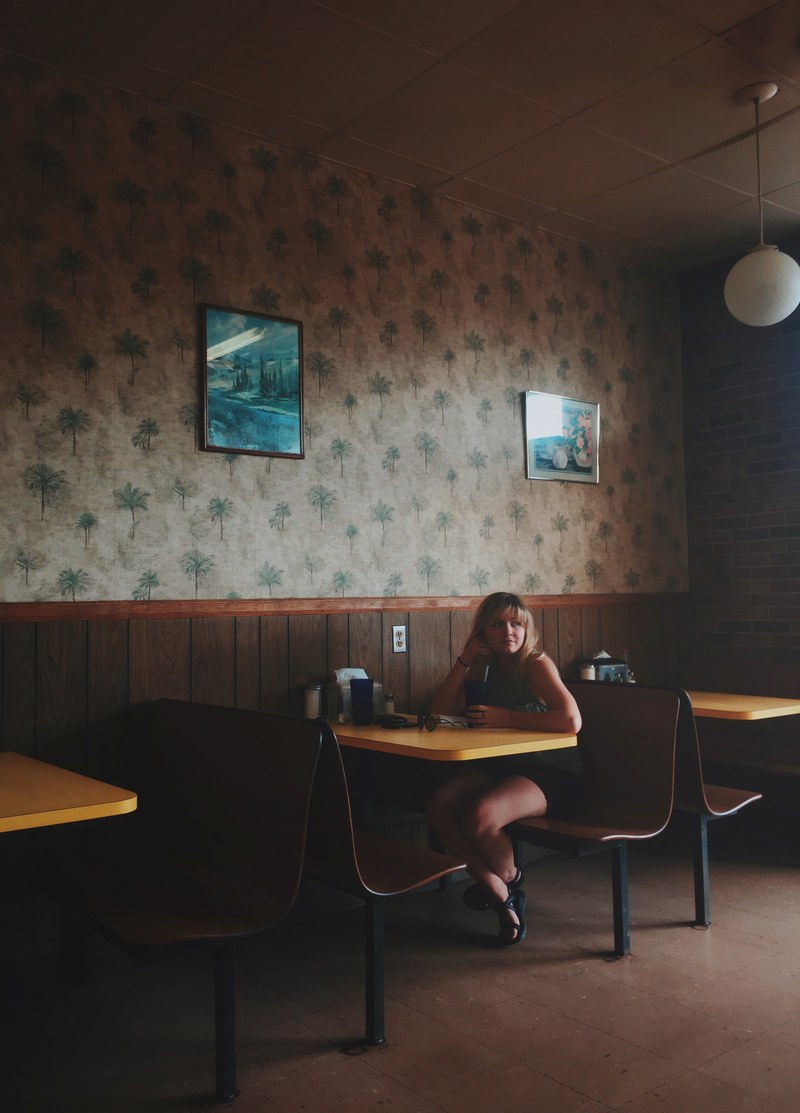a lone woman sitting at a table in a cozy caf, waiting in a caf 4k