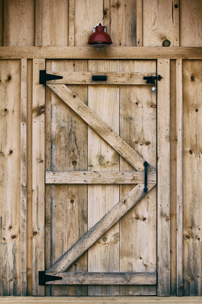 a wooden barn door with a red light above it in parry sound, lakeside door 4k