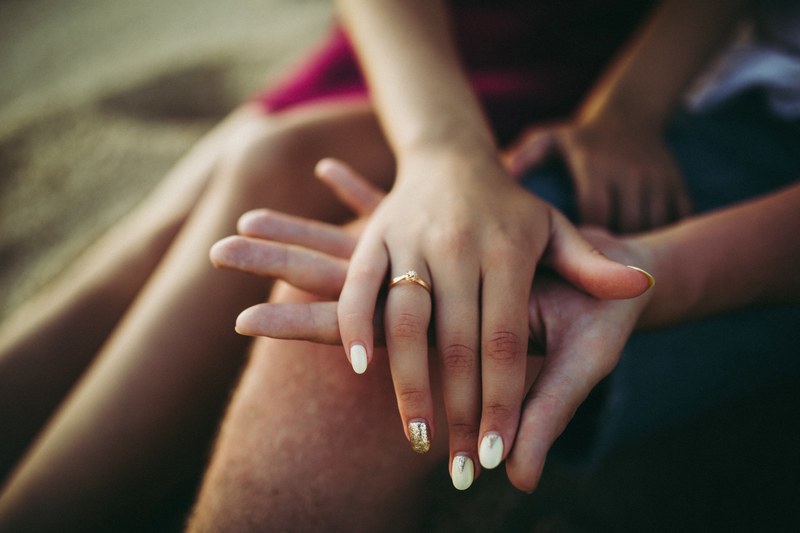 womans hand with a ring on a mans hand at nunggalan beach nyang nyang, marriage proposal 4k