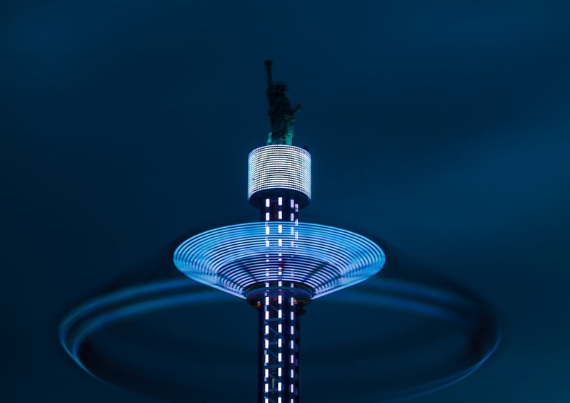 a look at lights in motion at an illuminated tower inside the luna park amusement park, spinning lights 4k