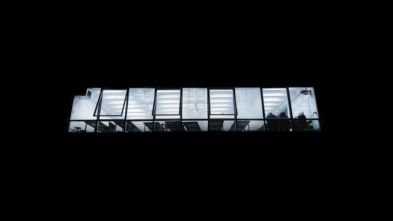 several people sitting at a canteen seen through a window from a dark street, studio 13 4k