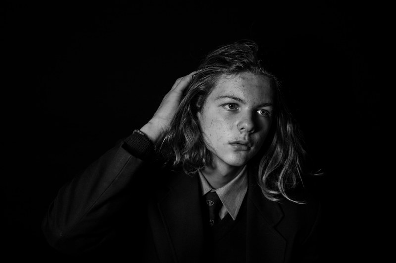 black and white shot of long haired male teenager posing while wearing shirt tie and blazer, known hand 4k