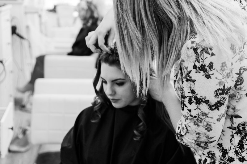woman gets her hair done by a stylist in a salon, curl gently 4k