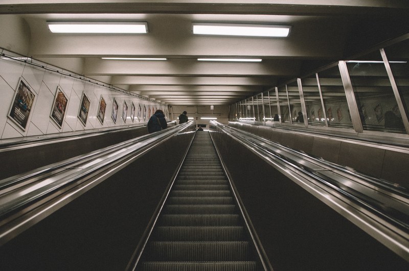 movie posters adorn the walls of the escalators in a subway station, _escalator lines 4k