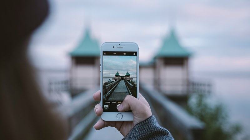 woman taking picture of interesting architecture on iphone with out of focus background persborg, lake house dalarna sweden 4k