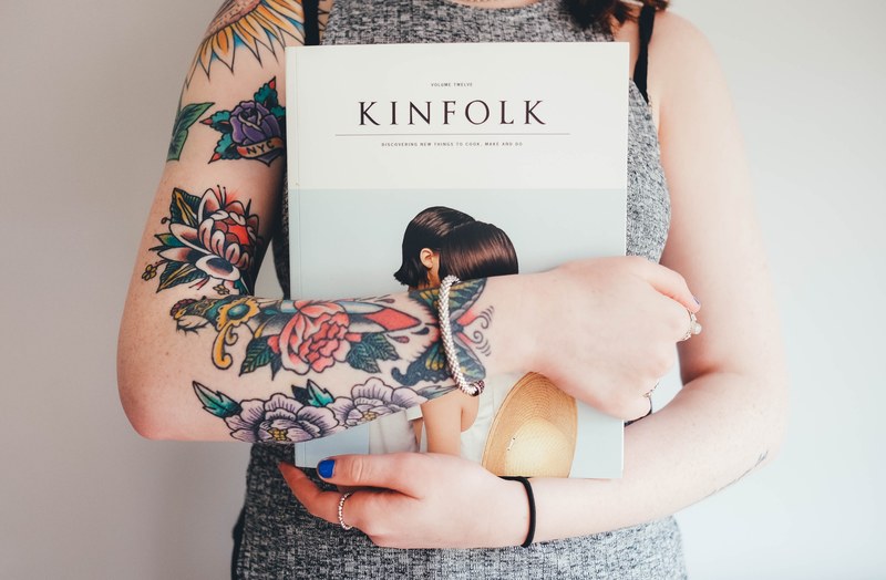 a woman with colorful floral tattoos holding a book in southampton, woman with tattoos 4k