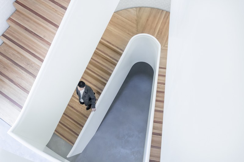 an overhead shot of a man in a suit on an elegant wooden staircase, man on a wooden staircase 4k