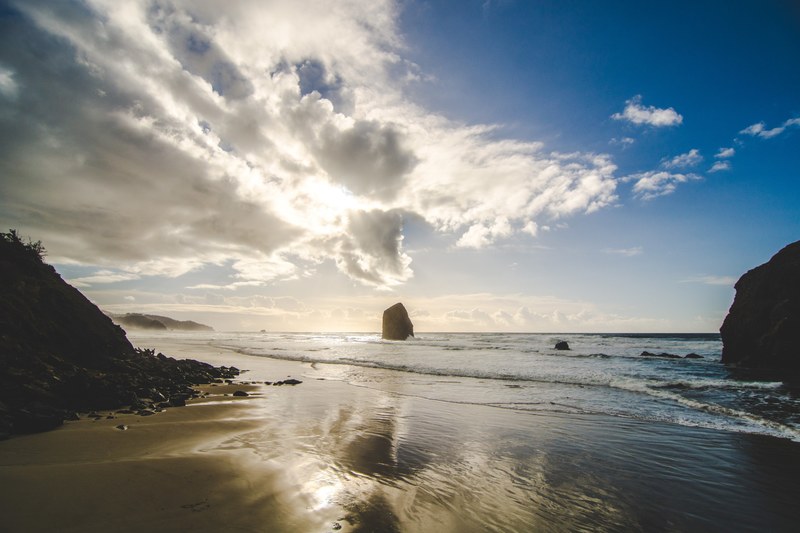 view of the horizon at dawn featuring ocean wave and rocks at beach shore, beach with rocky shore 4k