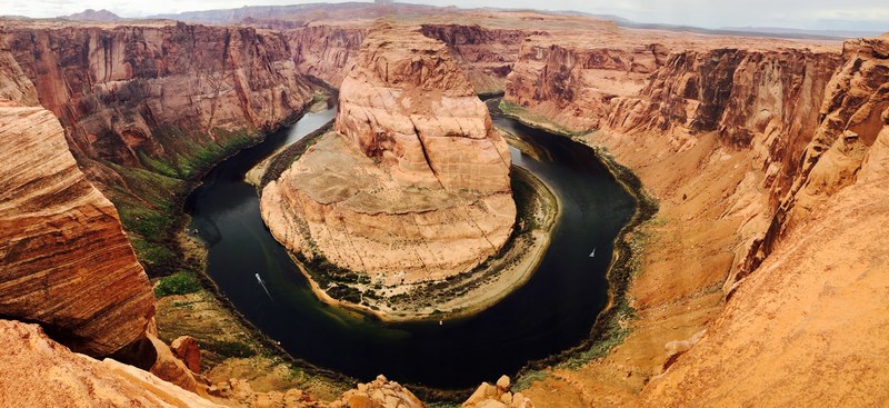 a horseshoe shaped river bend in a canyon on a sunny day, horseshoe bend on a sunny day 4k