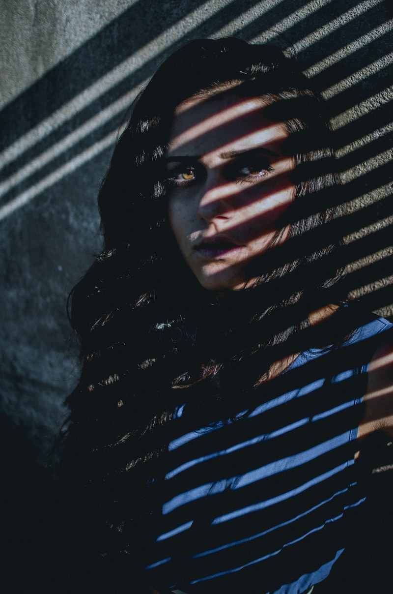 woman standing in the shadows of a slatted window, gabi lima 4k