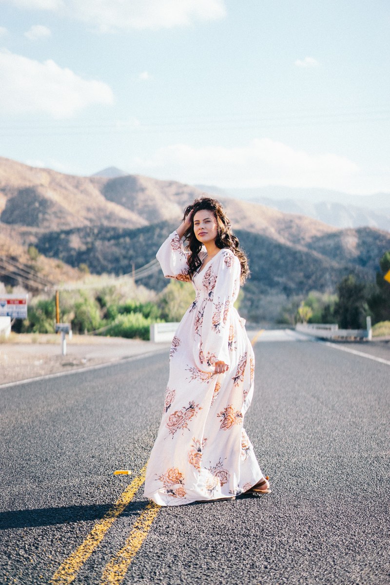 a woman wearing a long flowing white dress walking down the street in los angeles, los angeles woman in white 4k