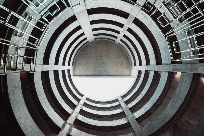 view from the bottom of a concrete well in lyon on the round opening above, in a concrete well 4k