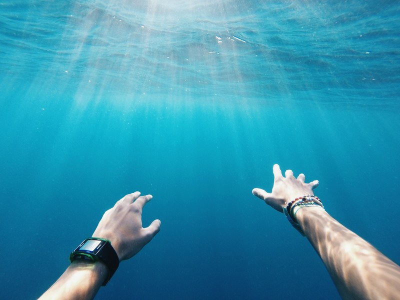a person wearing a smartwatch reaching out underwater, _underwater 2 4k