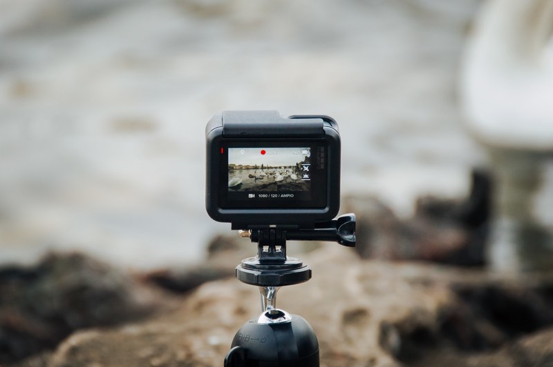gopro recording while on a tripod overlooking a rocky edge by a river, tiny video camera 4k