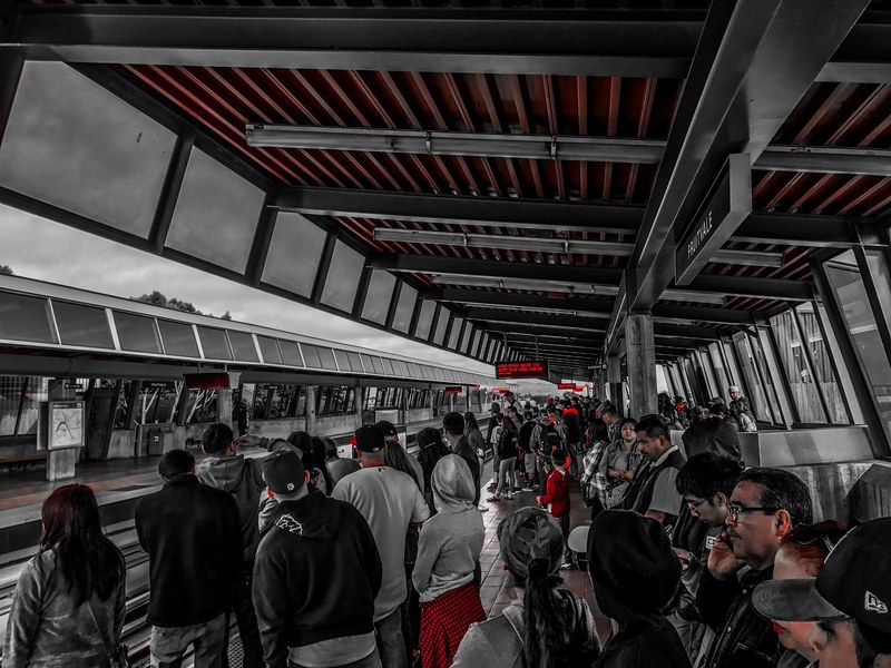 commuters waiting for a train at a crowded railway platform, train station in red and gray 4k