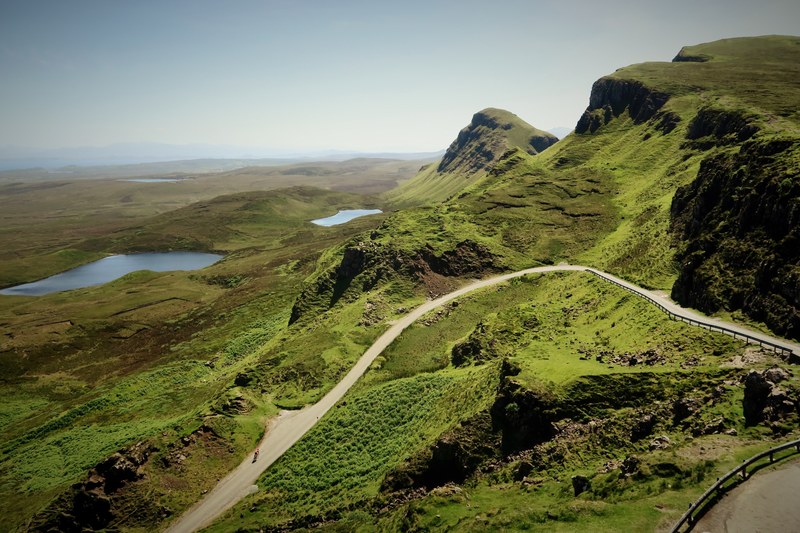 a road winding around a mountain overlooking a vast plain, mountain highway 4k