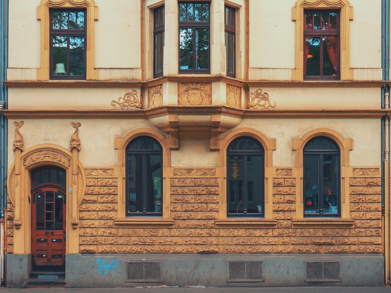exterior of a house with rounded windows and a red door, outside of a house 4k