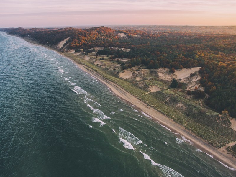 a drone shot of a lake and forest in autumn in holland michigan united states, every opportunity 4k